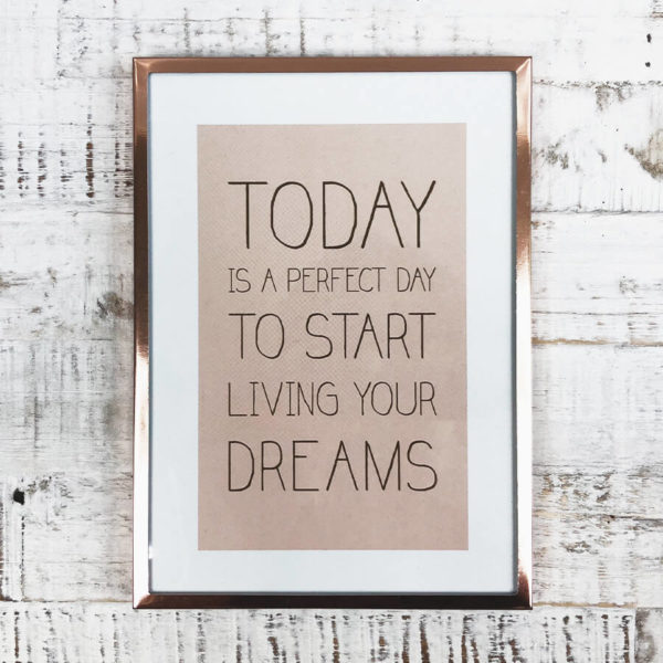 Rose goldener Bilderrahmen mit Bild "Today is a perfect day to start living your dreams" von oben auf einem Holzbrett fotografiert.