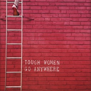Nahaufnahme der Polaroid Karte mit Aufschrift "Tough women go anywhere" und Frau in High Heels, die eine Leiter hochsteigt.