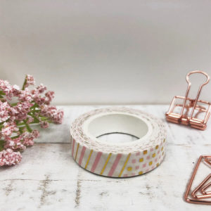 Washi Tape mit einem Muster aus rosanen und goldenen Elementen. Das Bild ist dekoriert mit rosé goldenen Clips und einer Blume.